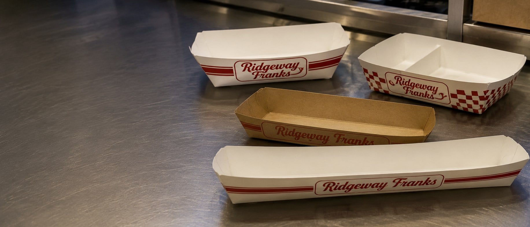 Custom printed hot dog trays with a logo stacked on a concession counter